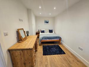 a bedroom with a bed and a wooden table at The Dairy in Swindon