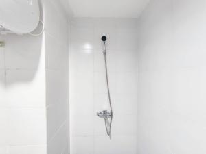 a shower in a bathroom with a shower head at Cozy Studio at 9th Floor Paltrow City Apartment By Travelio in Semarang