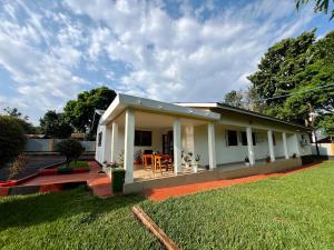 a small white house with a grass yard at Kivuli Lodge in Moshi