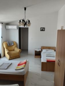 a living room with two beds and a chair at Braco apartments by the sea with a sea view in Zaboric