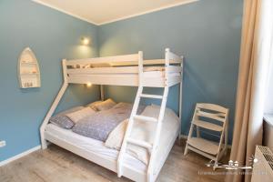 1 dormitorio con 2 literas y escalera en 42 Ferienwohnung im Birkenweg 1c EG, en Burg auf Fehmarn