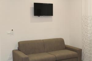 a living room with a couch and a tv on a wall at Le Palme - Holiday Home in Brindisi