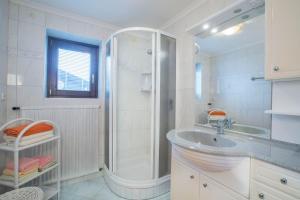 a white bathroom with a shower and a sink at Landhaus Vier Jahreszeiten in Krimml