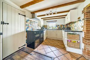 a kitchen with white cabinets and black appliances at The old pub in Docking in Docking