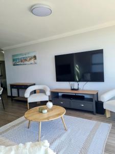 a living room with a tv and a coffee table at View At The Bay in Mossel Bay