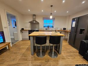 a kitchen with a kitchen island with two bar stools at The Dairy in Swindon