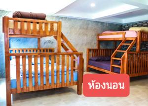 two bunk beds in a room with a red sign at Bigland Homestay in Bang Sare