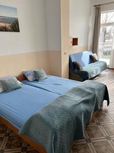 a bedroom with two beds and a chair at Rybitwa in Dziwnów