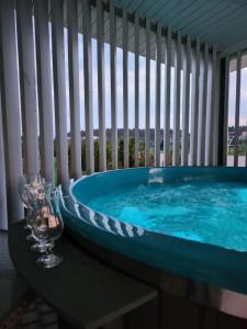 a jacuzzi tub on a balcony with a window at Atostogų pieva in Žibininkai