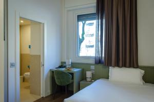 pokój hotelowy z łóżkiem i oknem w obiekcie Hotel Tiziano - Gruppo Mini Hotel w Mediolanie +29 zdjęć