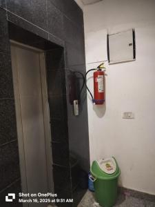 baño con extintor de incendios en la pared en Hotel DownTown, en Nueva Delhi