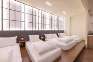 a room with four white couches in a room at H-Avenue Hotel Haeundae in Busan +102 photos