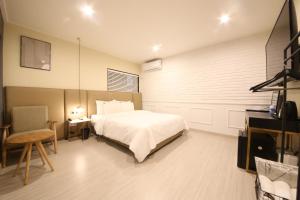 a bedroom with a bed and a table and a chair at Browndot Hotel Hwamyeong in Busan