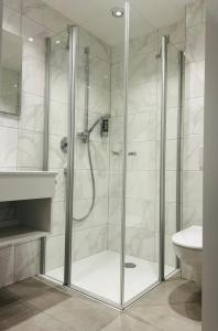 a shower with a glass door in a bathroom at Landhotel Sonnenbühl in Sonnenbühl