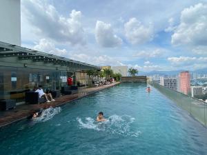 a group of people in a swimming pool on a building at Celestial Heights Hostel featuring Infinity Skypool in Kuala Lumpur
