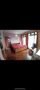 a bedroom with a bed and a desk with a computer at Himalayan tea pot in Darjeeling +2 photos
