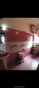 a bathroom with two toilets and a sink and a tub at Himalayan tea pot in Darjeeling
