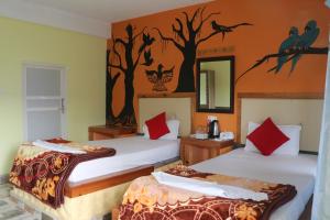 a hotel room with two beds and a mirror at Hong Qi Hotel in Chitwan