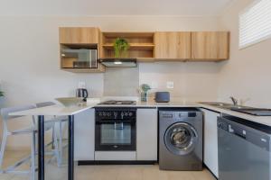 cocina con fogones y lavavajillas en Bliss Ballito Apartments, en Ballito