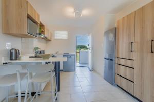 una cocina con encimera y algunas sillas. en Bliss Ballito Apartments, en Ballito