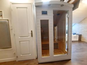 a small closet with a door in a room at L'Opale - Sauna et Jacuzzi in Dijon