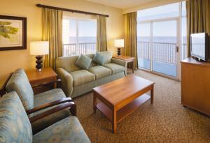 Una sala de estar con un sofá y un televisor. en Club Wyndham SeaWatch Resort, en Myrtle Beach