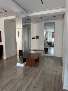 a living room with a wooden table and a mirror at Апартаменты в центре Худжанда in Khujand