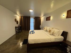 a bedroom with a large bed with white sheets and pillows at NUTMEG Cottage Siargao- Private room in General Luna +20 photos