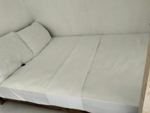 a white bed in a corner of a room at Manga's swimming pool in El Nido Airport