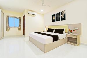 a white bedroom with a bed and a table at Super Collection O Sanath Nagar Near Railway Station in Hyderabad