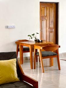 a wooden table and chair with a potted plant on it at Kivuli Lodge in Moshi +23 photos