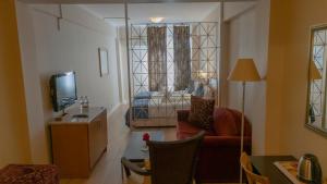a living room with a red chair and a television at Park Hotel in Edirne