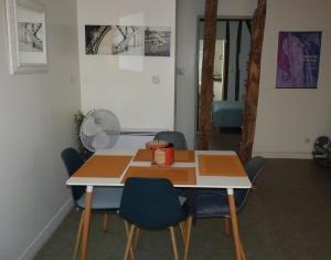 a room with a table and chairs and a fan at Le Libération in Limoges +14 photos