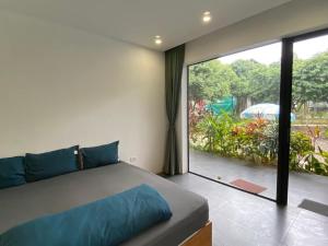 a bedroom with a bed and a large window at Large Mango Villa in Ba Vì