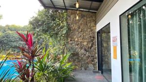 an entrance to a building with a stone wall and plants at Large Mango Villa in Ba Vì
