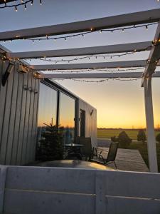 a patio with a table and chairs under a pergola at Cozy Hut with the included Hot Tub-Prime Rentals in Karališkiai