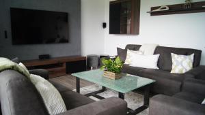 ein Wohnzimmer mit zwei Sofas und einem Tisch in der Unterkunft Ferienhaus Magnolie in der Eifel in Monschau + 37 Fotos