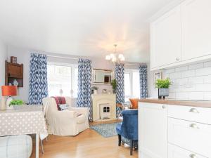 a kitchen and living room with blue and white curtains at No 1 The Heathers in Saint Cleer