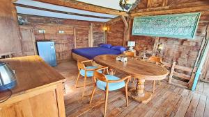 a room with a table and chairs and a bed at Fisherman Shack in Nusa Lembongan