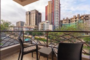 a balcony with two chairs and a view of a city at Highlands Suites Hotel Apartments in Nairobi