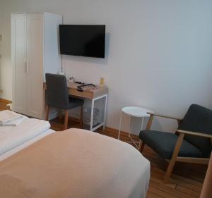 a room with a desk and a tv and a bed at Land-Gut-Hotel- Weisser Schwan in Zossen