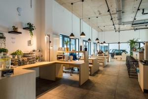 a large office with tables and chairs and people at AR City Hotel Berlin in Berlin