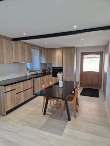a kitchen with a black table and wooden cabinets at Campagne - appartement rénové avec 2 chambres in Estavayer-le-Lac