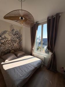 a bedroom with a bed and a large window at Studio 2 Chartres gare et Colisée a 100 m in Chartres