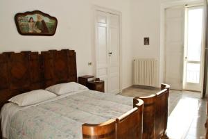 IrsinaにあるNomadi Sedentari - Irsinaのベッドルーム1室(大型木製ベッド1台付)