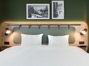 a bedroom with two beds and two pictures on the wall at Campanile PRIME - Paris Ouest Boulogne in Boulogne-Billancourt