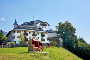 a large building on top of a grassy hill at Hotel Schloss Mittersill in Mittersill