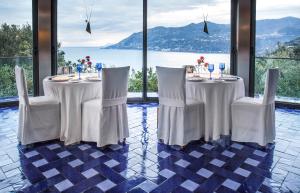 a dining room with two tables and chairs with a view at Tenuta Solomita in Maiori