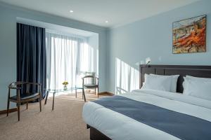 迪利然Ani Forest Hills Hotel and Resort, Dilijan的一间带床和玻璃桌的酒店房间
