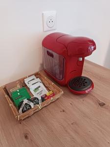 a red toaster sitting on top of a wooden floor at Appartement moderne et bohème in Vittel